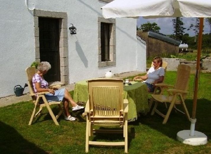 Gezellige woonkamer in vakantiehuis Ti Cos Kaourintine, Briec de l'Odet, Bretagne met open haard en comfortabele zithoek.