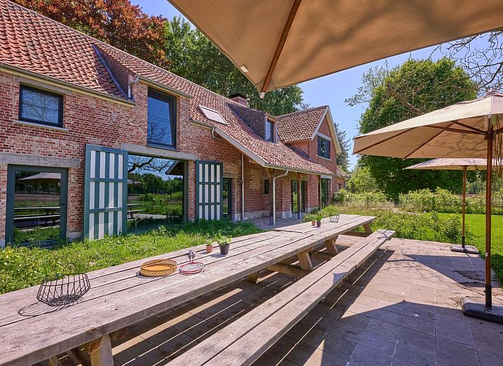 Lactea vakantiehuis in Schilde, Antwerpen omgeven door groene natuur met charmant terras en rustieke architectuur.