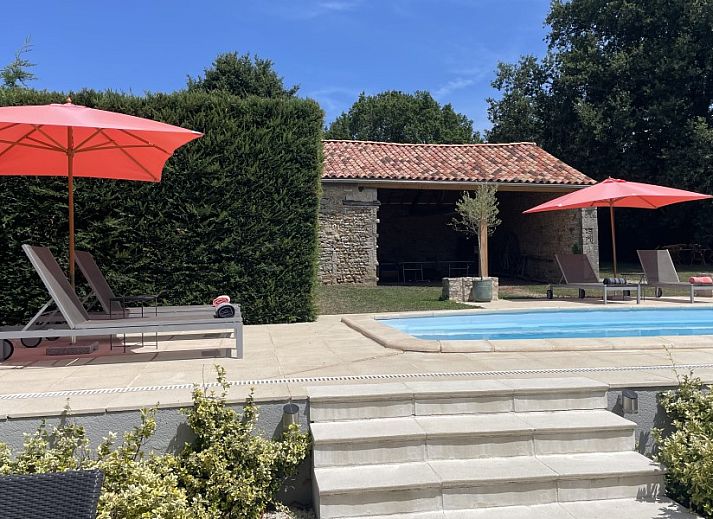 Ontspan in de tuin van Le Reve de Breuillac, een charmant vakantiehuis in Civray, Poitou-Charentes, met zwembad en groene omgeving.