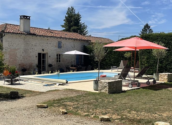 Ontspan in de tuin van Le Reve de Breuillac, een charmant vakantiehuis in Civray, Poitou-Charentes, met zwembad en groene omgeving.