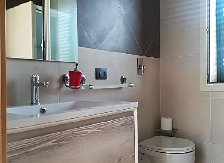 Villa Verdemare, een charmant vakantiehuis in Noto, Sicilie, met een uitnodigende entree omgeven door palmbomen.