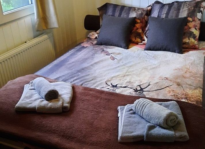 Sonnige Aussicht auf das Chalet d'Achouffe, Achouffe-Houffalize, mit umliegenden Baeumen in den Ardennen.