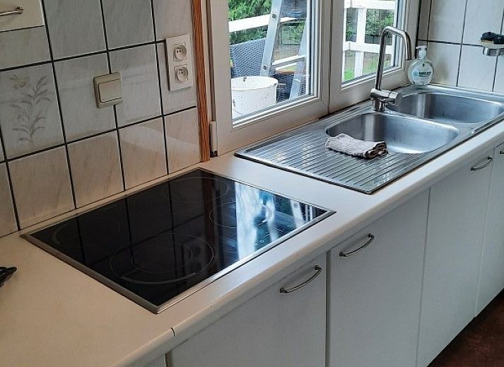 Sonnige Aussicht auf das Chalet d'Achouffe, Achouffe-Houffalize, mit umliegenden Baeumen in den Ardennen.