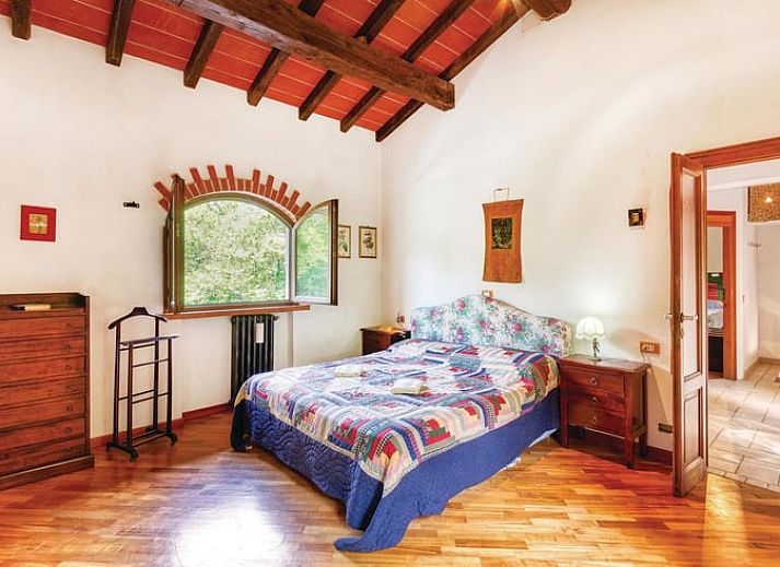 Geniet van de groene tuin bij Vakantiehuis in Mulazzo, Toscane, Italie, met comfortabele stoelen en parasol.