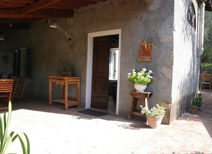Ontspan op de veranda van vakantiehuis Rosmarino in Castagneto Carducci, Toscane, met uitzicht op de groene natuur.