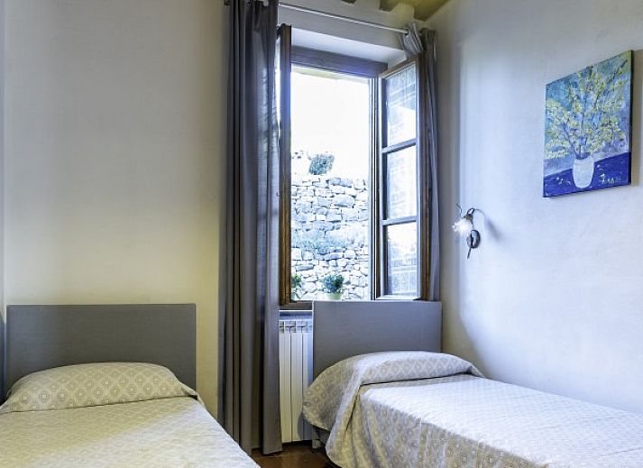 Geniet van de serene tuin bij vakantiehuis Alfoionco in San Macario, Toscane, met een prachtig terras en bloeiende bloemen.