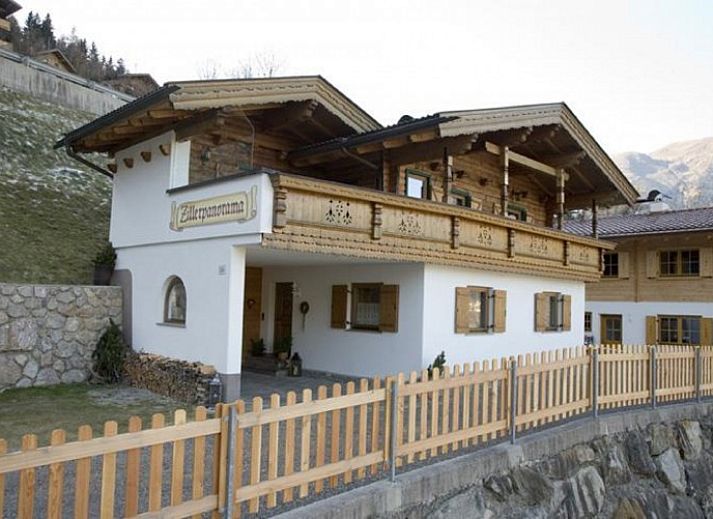 Chalet Hainzenberg in Zell am Ziller, Tirol, biedt een charmant verblijf te midden van een besneeuwd berglandschap.