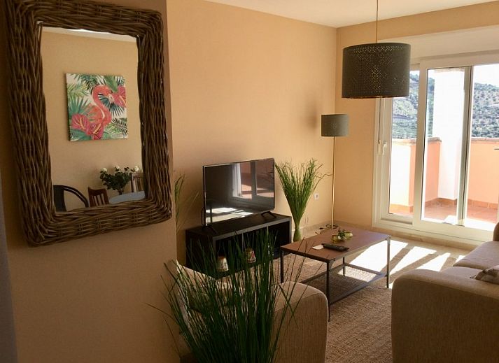Gezellige woonkamer van Al Cautin appartement in Alcaucin, Andalusi met uitzicht op de bergen en een uitnodigend terras.