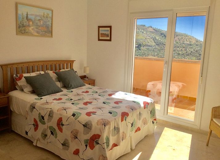 Gezellige woonkamer van Al Cautin appartement in Alcaucin, Andalusi met uitzicht op de bergen en een uitnodigend terras.