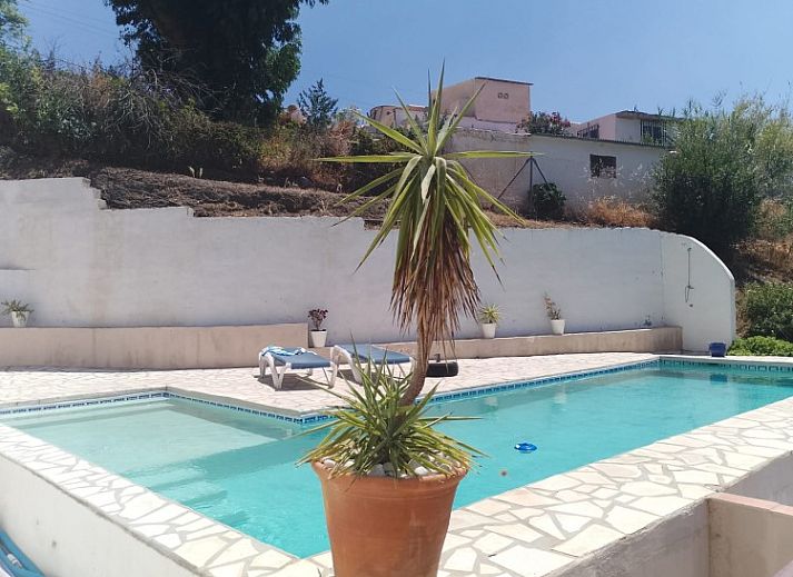 Gezellige woonkamer in Casa Milvan, vakantiehuis in Competa, Andalusie met open haard en antieke kast.