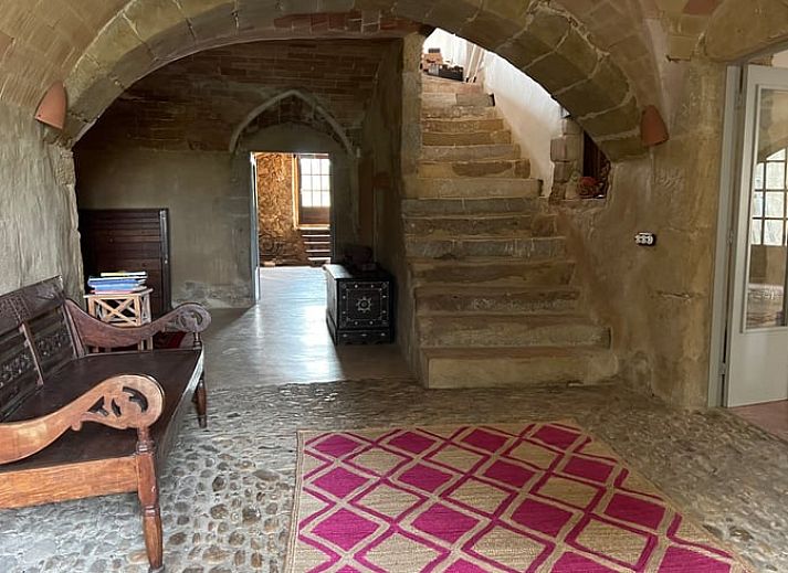 Gezellige slaapkamer in Vakantiehuisje in Navata, Costa Brava, met rustieke muren en moderne kunst.