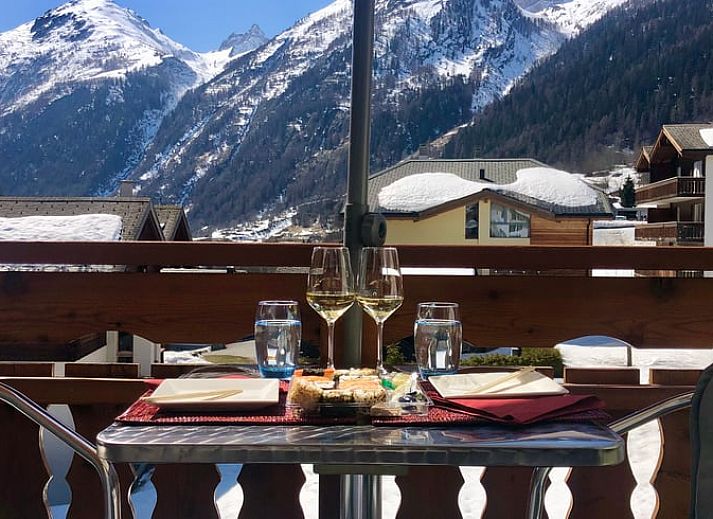 Innenraum des Ferienhauses in Kippel, Wallis, mit grossen Fenstern und Blick auf die schneebedeckten Berge.