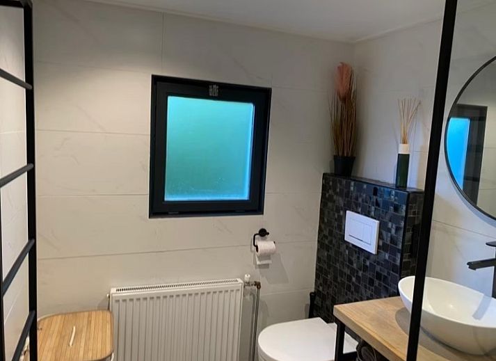 Rustic back of Cottage 54 in Wateren, Drenthe, with wooden fence and shaded area.