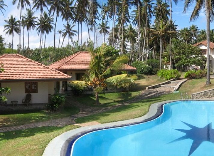 Ontspan bij Briddens Cabanas in Katuneriya, Sri Lanka, met een prachtig zwembad en weelderige natuur rondom de vakantiehuizen.