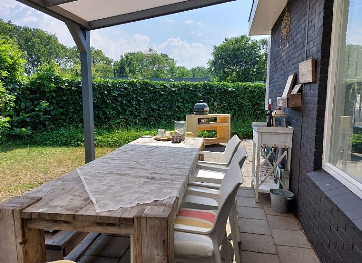 Gezellige woonkamer van vakantiehuis De Garnaal in Renesse, Zeeland met sfeervolle inrichting en uitzicht op de tuin.