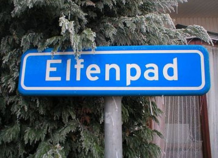 Elfenpad vakantiehuis in Westenschouwen, Zeeland met groene omheining en zonnige omgeving.