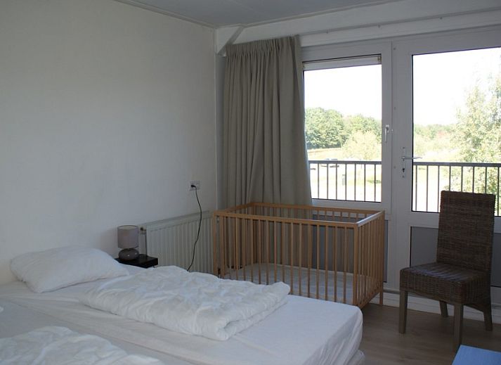 Stijlvolle woonkamer van la Cabane in Nieuwvliet-Bad, met eettafel, open haard en toegang tot terras.