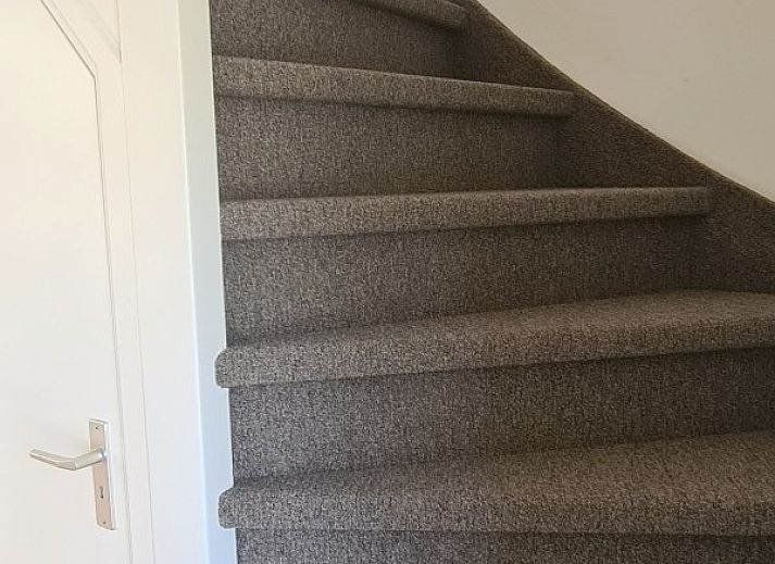 Gezellige woonkamer van Inlaag24 vakantiewoning in Wolphaartsdijk, Zeeland, met comfortabele banken.