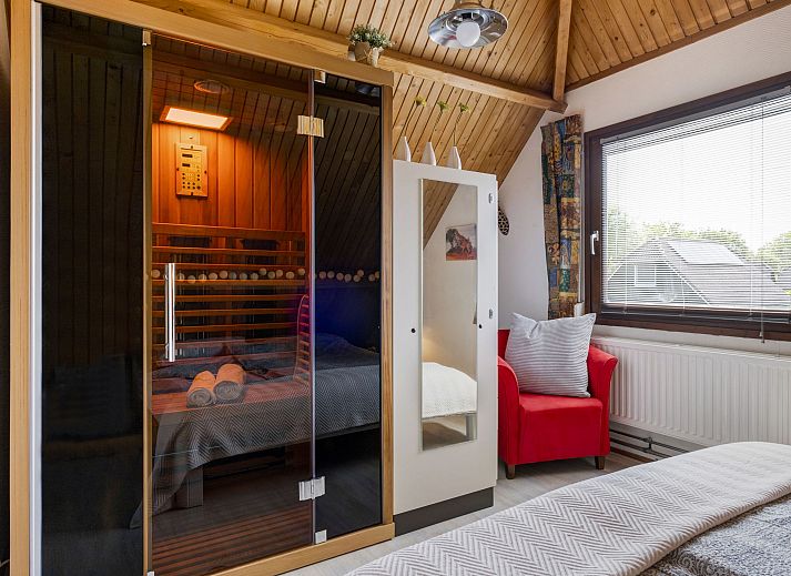 Geniet van de zonnige tuin bij Vakantiehuis Haus Anni in Hansweert, Zuid-Beveland, met comfortabele zithoek en parasol.