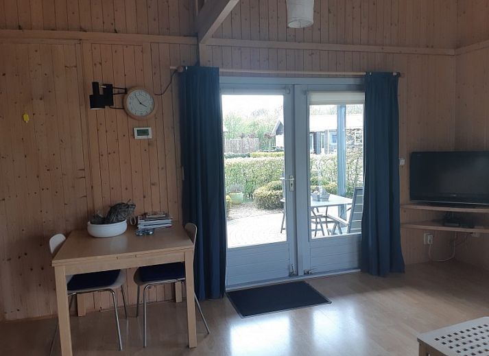 Gezellig terras bij Pinquin 31 vakantiehuis in Rockanje, omgeven door groene natuur in Voorne Putten, perfect voor buiten dineren.