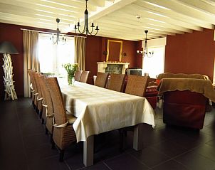 Buitenzijde van Hof ter Harte vakantiehuis, Ieper, West-Vlaanderen met rode accenten en bloeiende hortensia's.