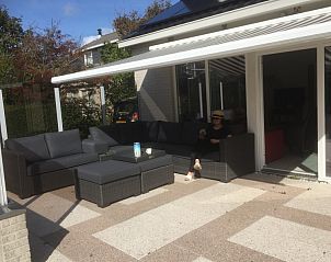 Comfortabele zithoek op het terras van Huize 100-1, vakantiehuis in De Koog, Texel, ideaal voor ontspanning.