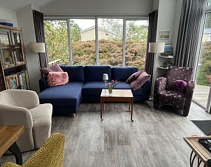 Lichte woonkamer in Spreeuw88 chalet, Den Hoorn, Texel met comfortabele meubels en uitzicht op terras.