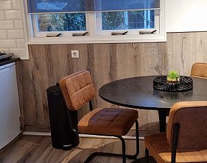 Eethoek in Bruinverhuurt Oudeschild, vakantiehuis op Texel, met gezellige tafel en stoelen voor een ontspannen maaltijd.