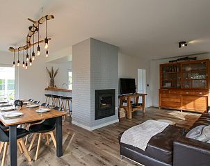 Ruime woonkamer van Villa de Strandjutter in Nieuwpoort-Bad, West-Vlaanderen, met moderne inrichting en open haard.