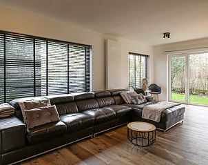 Gezellige zithoek in Villa de Strandjutter, vakantiehuis in Nieuwpoort-Bad, met uitzicht op de tuin in West-Vlaanderen.