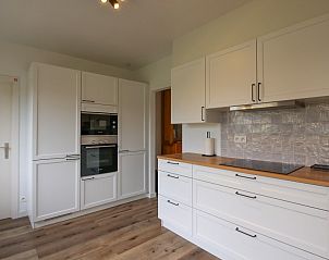 Moderne keuken in Villa de Strandjutter, vakantiehuis in Nieuwpoort-Bad, met strakke witte kasten en houten werkblad.