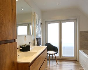 Luxe badkamer in Villa de Strandjutter, Nieuwpoort-Bad, met houten meubels en moderne verlichting in West-Vlaanderen.