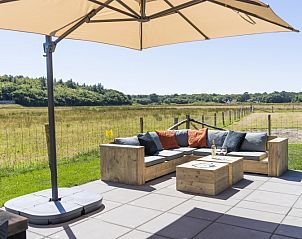 Terrace of Rovershut - Family House 2 in De Dennen, Texel, with comfortable lounge sofa and wide views of nature.