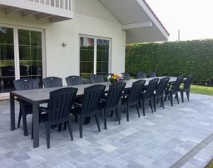 Ruim terras met lange eettafel bij Villa Blanche, vakantiehuis in Lauwe, West-Vlaanderen.