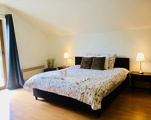 Lichte slaapkamer met groot bed in Villa Blanche, vakantieaccommodatie in Lauwe, West-Vlaanderen.
