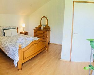 Gezellige slaapkamer met houten meubels in Villa Blanche, vakantiewoning in Lauwe, West-Vlaanderen.