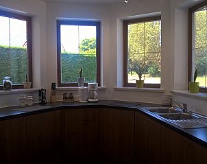 Moderne keuken in Villa Blanche, vakantiewoning in Lauwe, West-Vlaanderen, met uitzicht op de tuin.