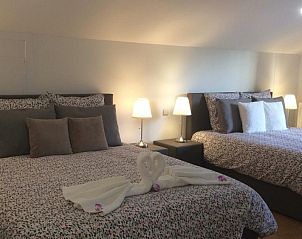 Moderne slaapkamer met dubbele bedden in Villa Blanche, vakantieaccommodatie in Lauwe, West-Vlaanderen.