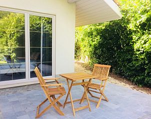 Klein terras met houten stoelen bij Villa Blanche, vakantiewoning in Lauwe, West-Vlaanderen.