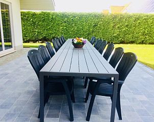 Terras met lange tafel en stoelen bij Villa Blanche, vakantiehuis in Lauwe, West-Vlaanderen.