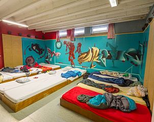 Creatieve slaapruimte in De Bosgeus vakantiehuis in Nieuwkerke, West-Vlaanderen met kleurrijke muurschilderingen.