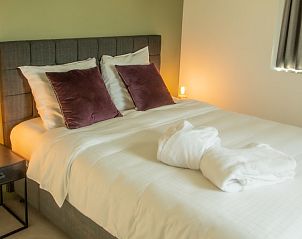 Sfeervolle slaapkamer in Villa Steedje, een vakantiehuis in Jabbeke, West-Vlaanderen, Belgi, met luxe beddengoed en zachte verlichting.