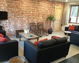 Gezellige zithoek in de Kortweunste vakantiehuis, Merkem, met grote ramen en uitzicht op de groene omgeving.