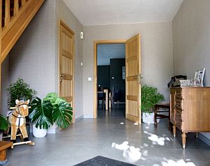 Gezellige entree met houten trap in Vakantiewoning Huis Huwyn, Lichtervelde, ideaal voor een warm welkom.