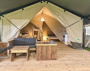 Safari tent in Aars, North Jutland: a luxury glamping lodge with a cozy interior and wooden furniture.