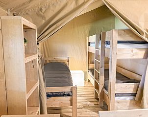 Cozy bedroom in a safari tent in Aars, North Jutland, Denmark, featuring wooden bunk beds and a warm, inviting atmosphere.