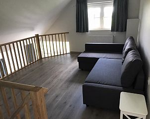 Zolderruimte met zithoek in Les Frres vakantiehuis, Middelkerke, ideaal voor ontspanning.