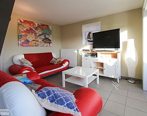Comfortabele woonkamer in Zee en Polder vakantiehuis, Westende, Belgische kust, met kleurrijke banken.