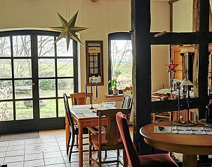 Gezellige eetkamer in Vakantiehuis in Syke, Nedersaksen, met uitzicht op de tuin en rustieke inrichting.