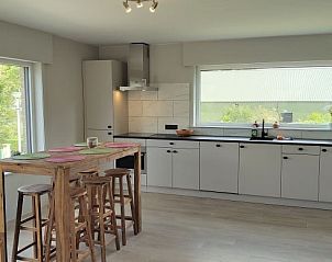 Open keuken met houten eettafel in Villa 't Zonneroosje, vakantiehuis in Nieuwpoort.